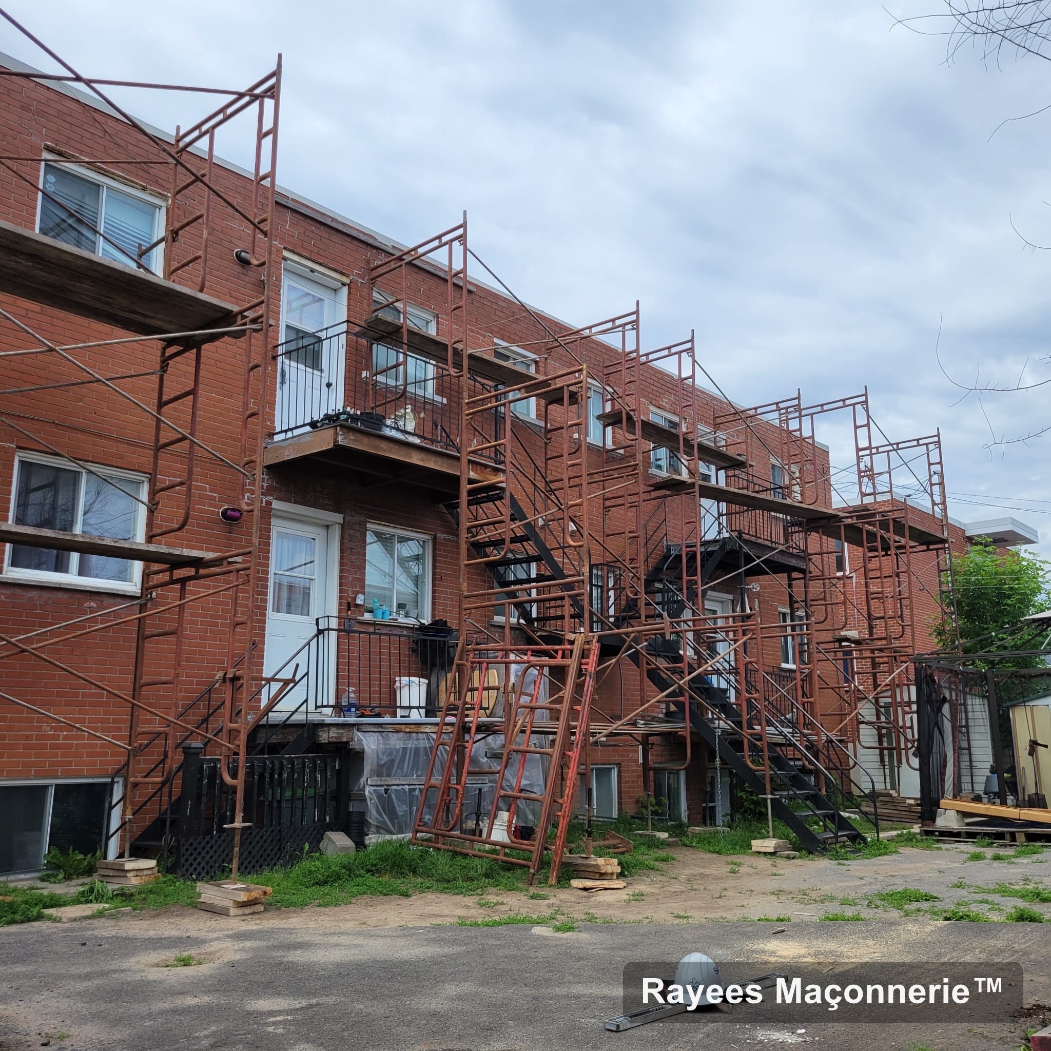 Chantier de maçonnerie avec échafaudage sur un triplex