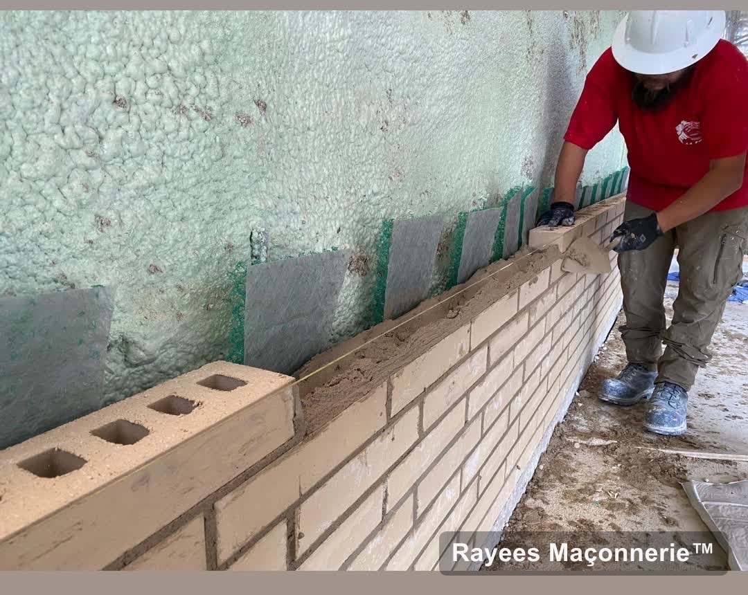 Maçon de Rayees posant de la brique crème